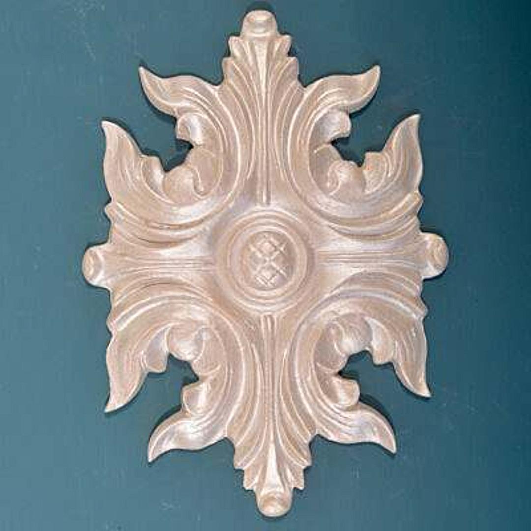 R116 Efex flexible moulding applique of four curling acanthus leaves around a central rosette with a crosshatched button, on a teal background
