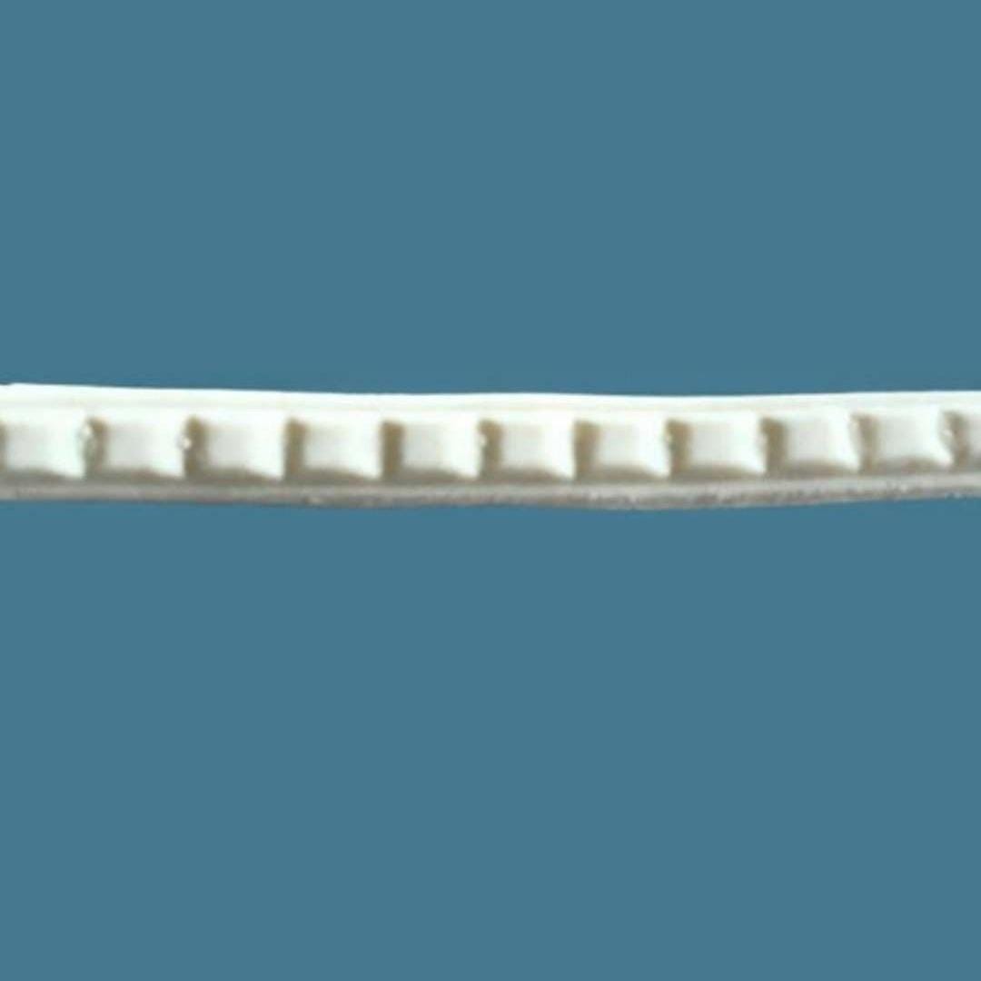 T50 Small Dentil Molding, a slim Efex flexible moulding strip of small square dentil blocks, on a blue background