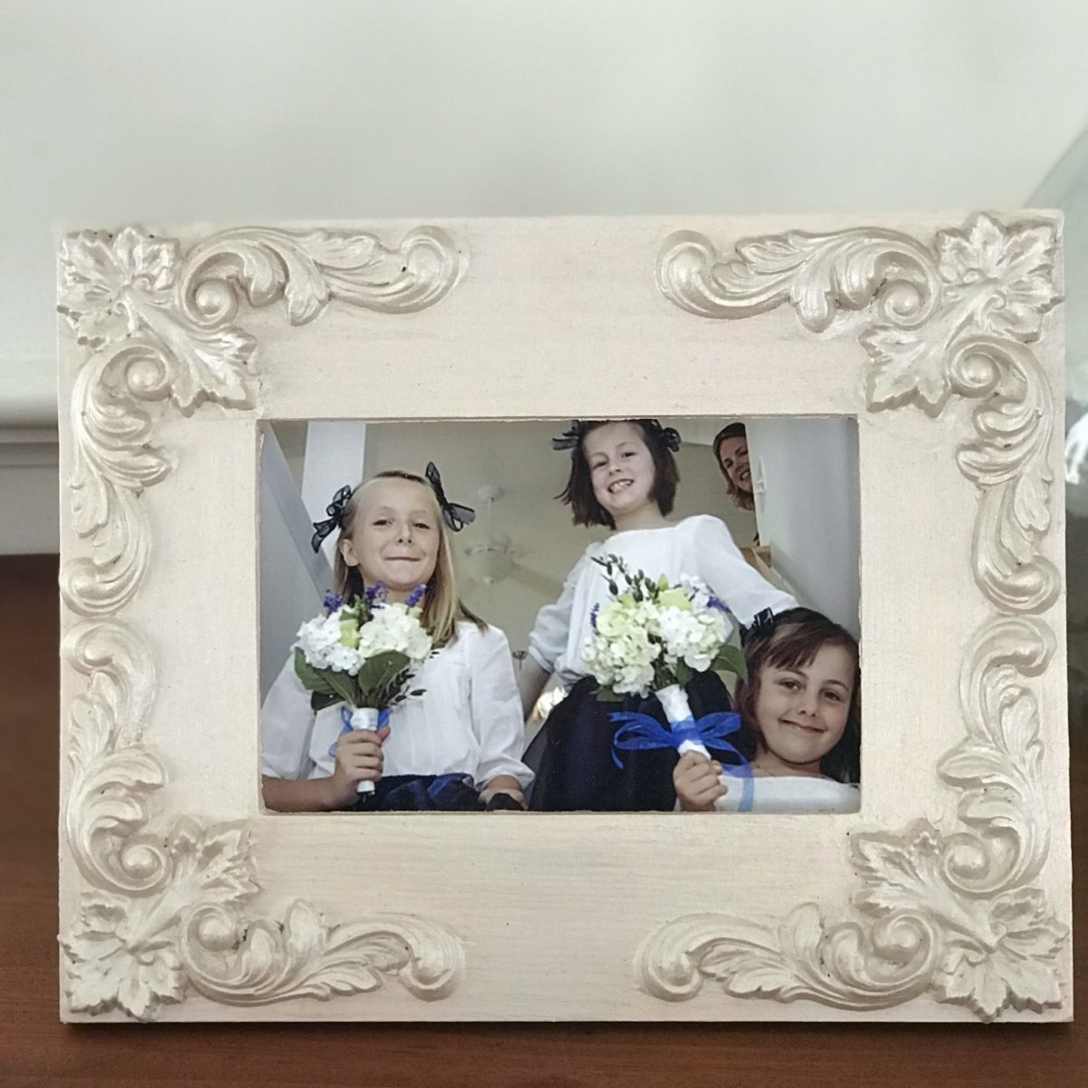 Cream photo frame decorated with C45 French Country Corner Efex flexible mouldings in a pearl finish, holding a photo of young flower girls