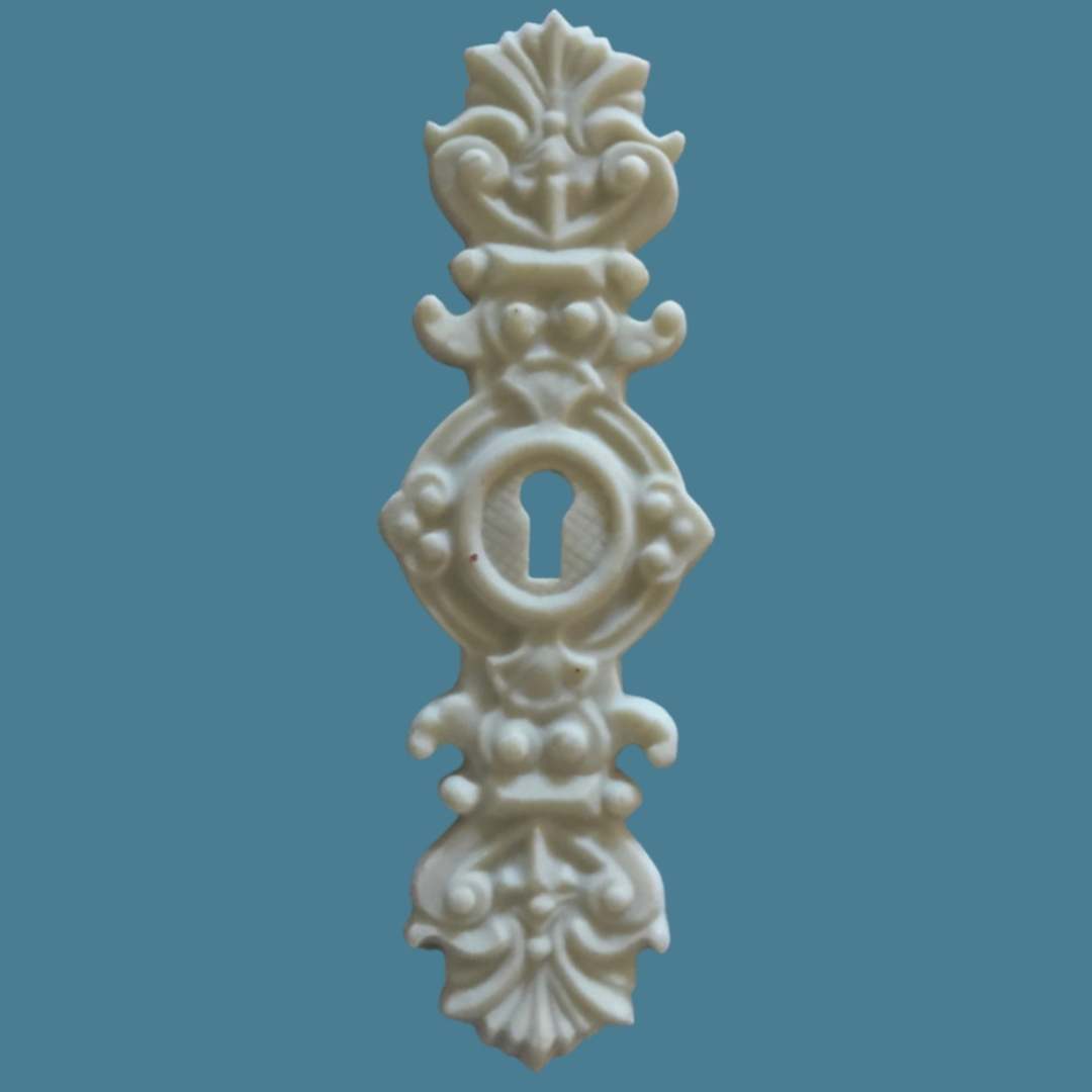 E3 Large Escutcheon, a tall Efex flexible moulding keyhole plate with an ornate oval keyhole surround and carved finials above and below