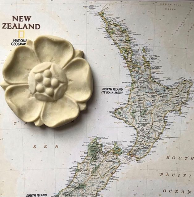 R9 Poppy Rosette, a five-petal Efex flexible moulding poppy flower resting on a map of New Zealand