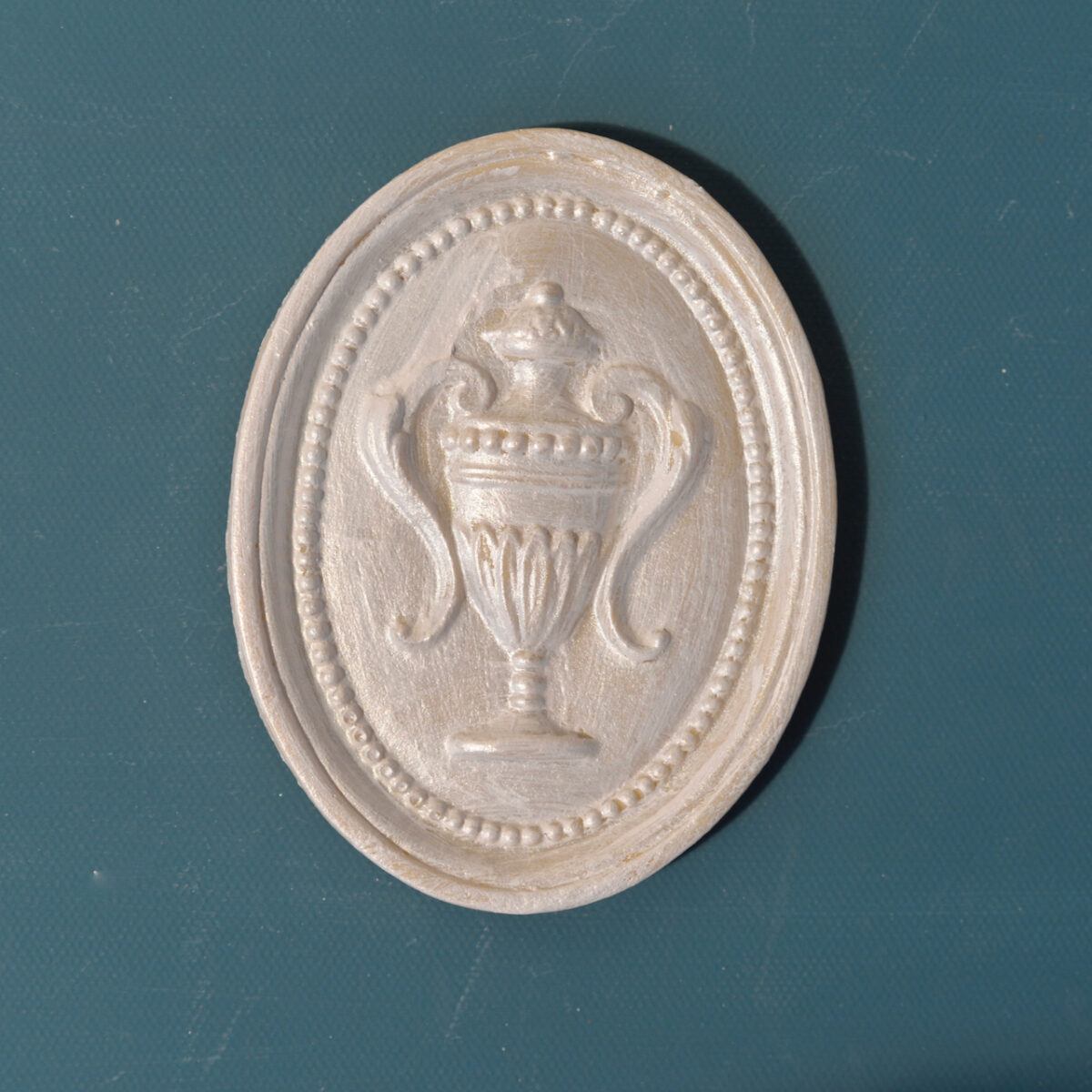 R11 Federal Urn in Oval, an Efex flexible moulding oval plaque with a raised classical urn and scroll handles inside a beaded frame
