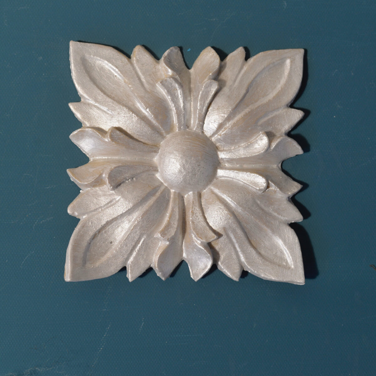 R111 Large Sunflower Rosette, a square Efex flexible moulding applique of layered pointed petals around a domed centre, pearl finish