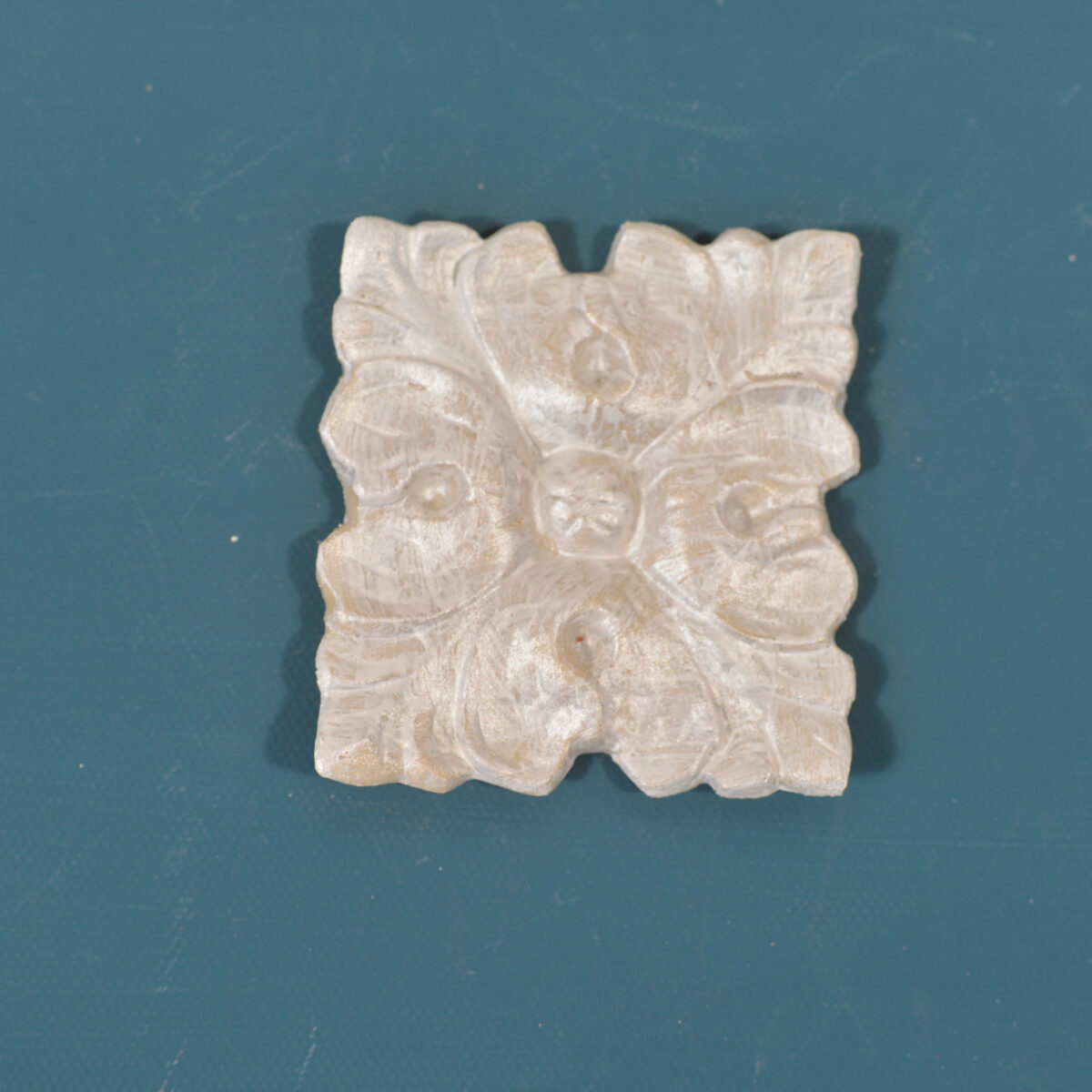 R114 Square Rococo Rosette, a square Efex flexible moulding block carved with curling leaves around a centre flower, pearl finish