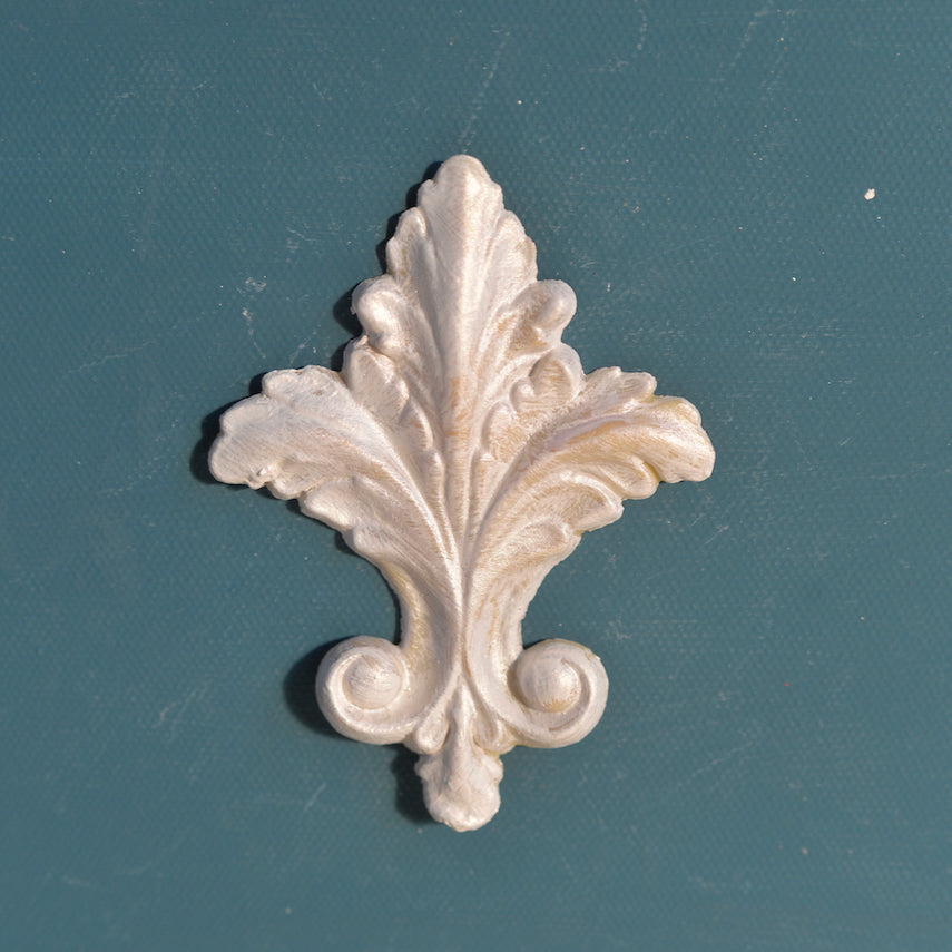 FDL1 Fleur de Lis Efex flexible moulding, a tall acanthus leaf fleur-de-lis with scroll base and drop, in a pearl finish