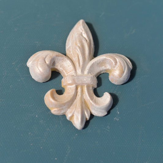 FDL4 French Fleur de Lis Efex flexible moulding finished in pearl and gold, shown on a teal background
