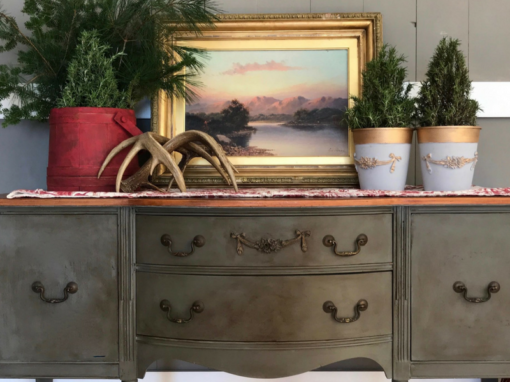 Painted green sideboard with an SW9 Rose Swag Efex flexible moulding on the centre drawer, styled with a gilt-framed landscape, antlers and potted topiaries