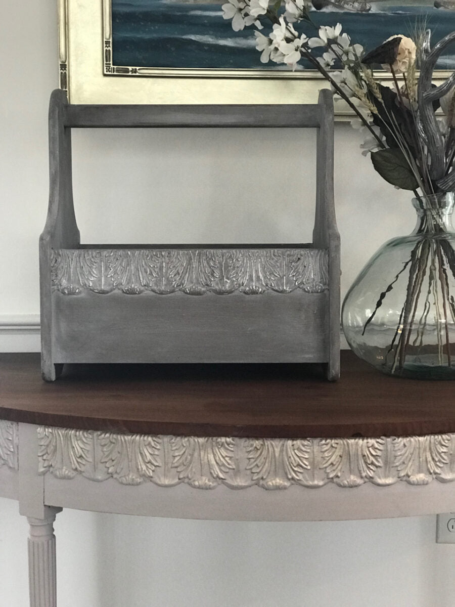 Grey wooden tool caddy and a white demilune console table, both trimmed with T34 Large Acanthus Leaf Efex flexible moulding in a whitewashed finish